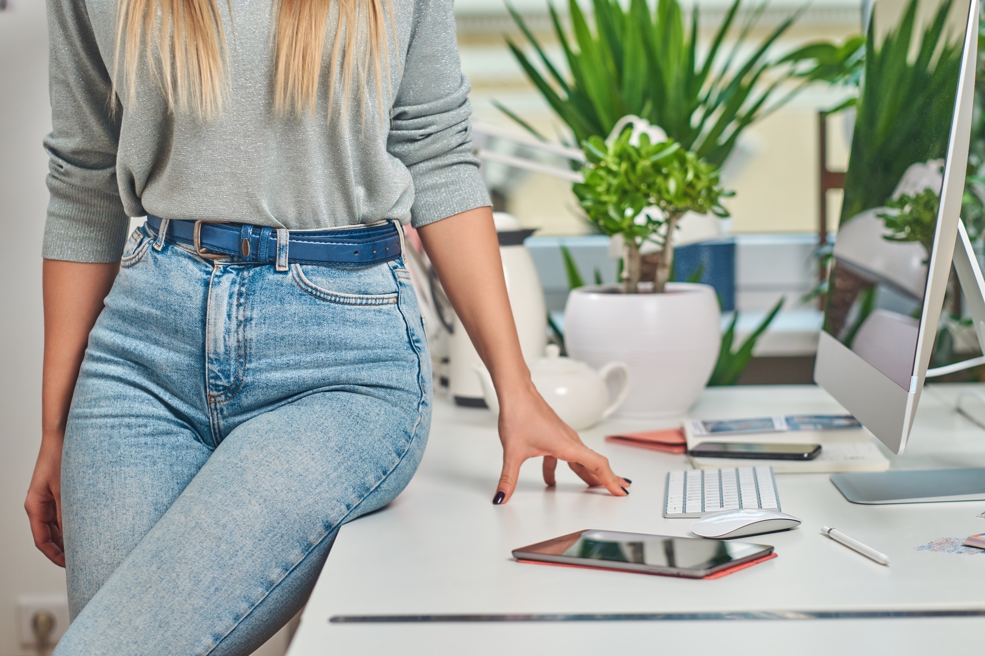 Woman in jeans is sitting on the table